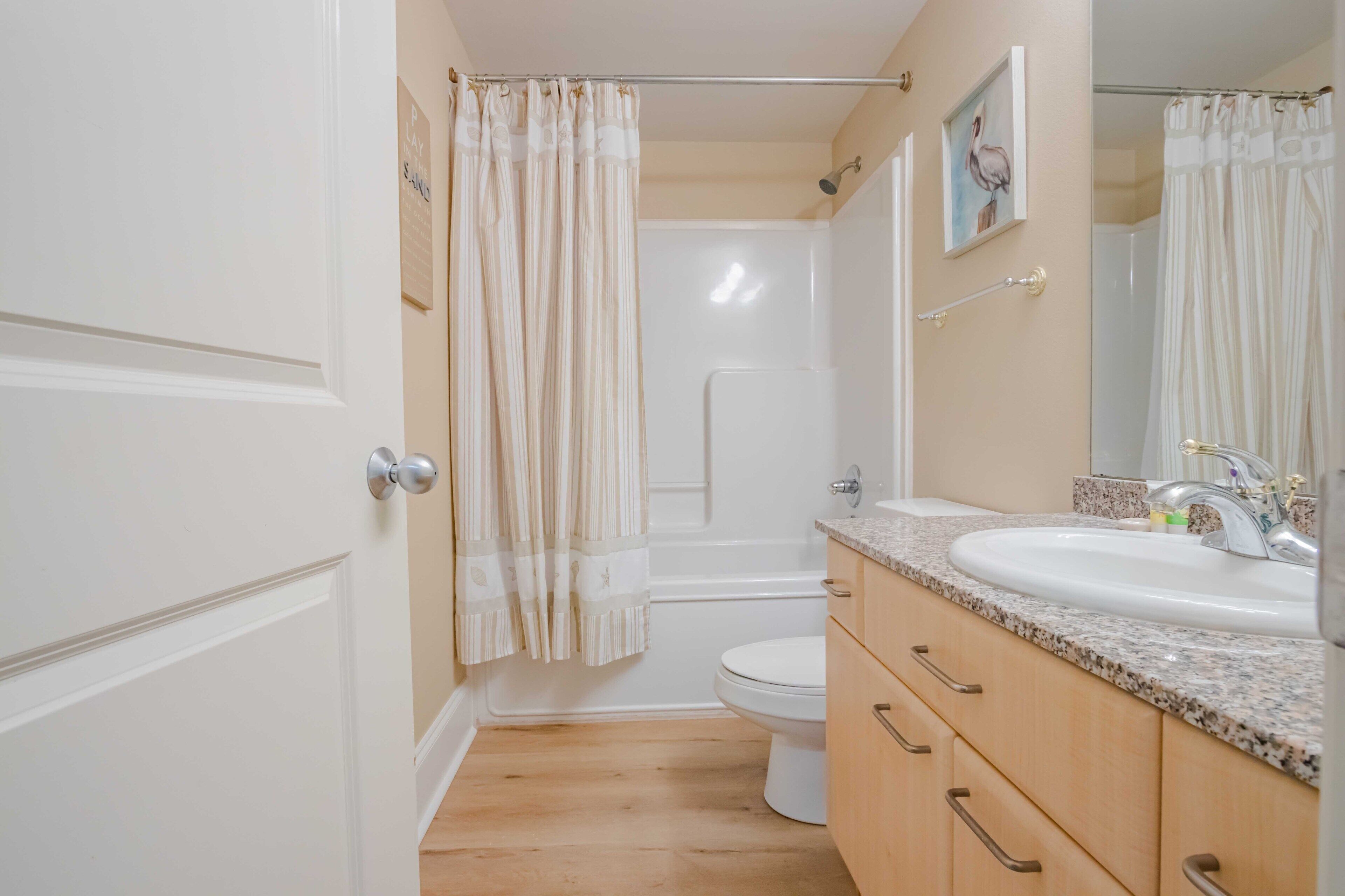 A bathroom with a shower, toilet, and sink.