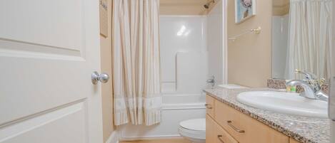 A bathroom with a shower, toilet, and sink.