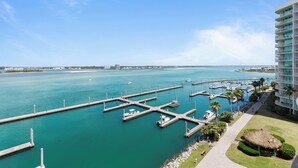A marina with docks, boats, and a hotel with balconies overlooking the water. - Chic Coastal Cottage with Bay Views! Complimentary Boat Slip! (Orange Beach)