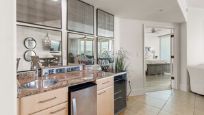 A modern kitchen with a granite countertop, stainless steel sink, and a 'BE KIND ALWAYS' sign. - Chic Coastal Cottage with Bay Views! Complimentary Boat Slip! (Orange Beach)