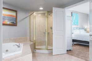 Een bad/douchecombinatie, een bubbelbad, een haardroger, handdoeken