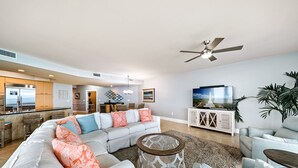 A spacious living area with a large sectional sofa, a coffee table, and a television.