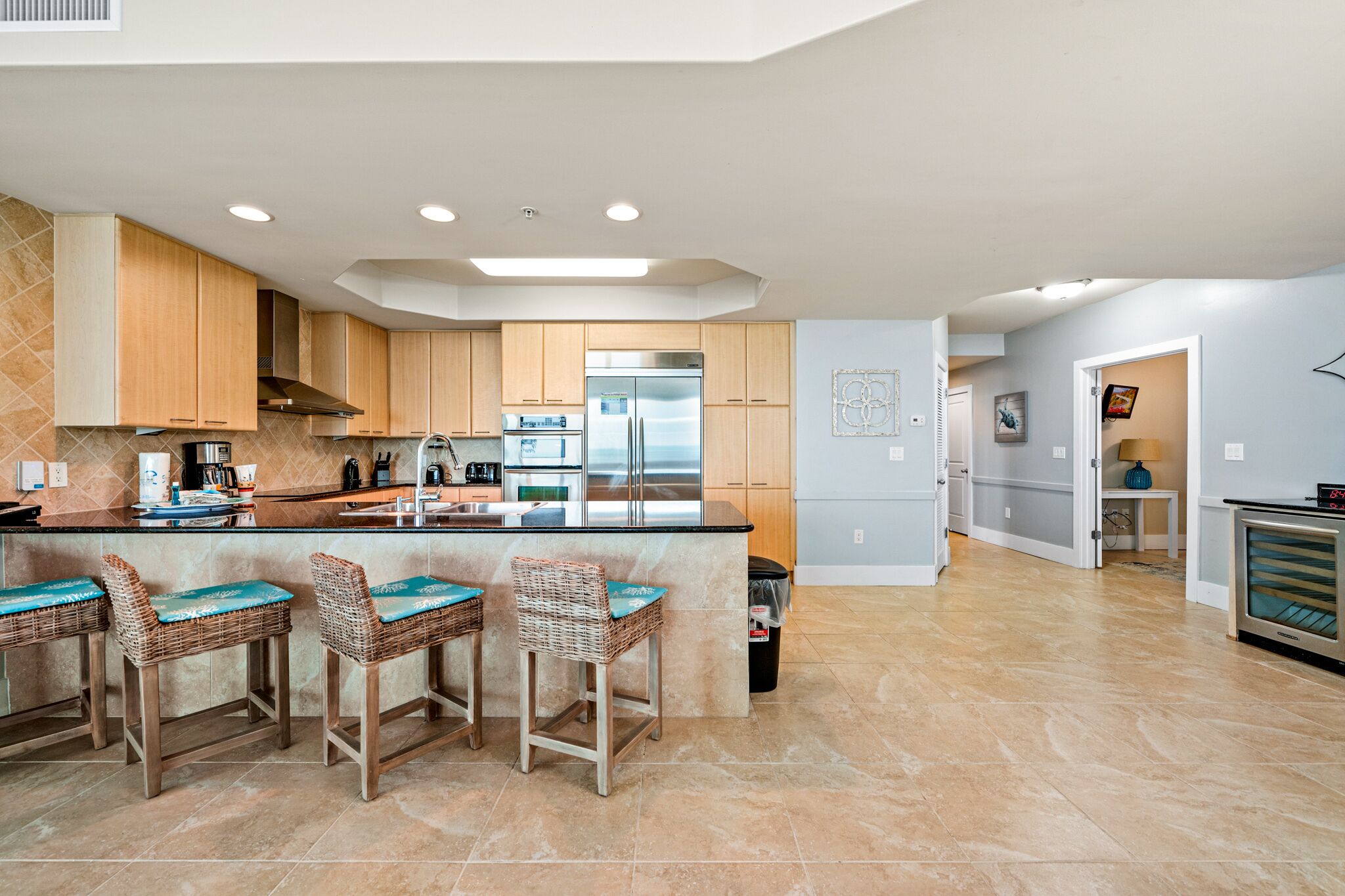 A modern kitchen with wooden cabinets, stainless steel appliances, and a central island with bar stools.