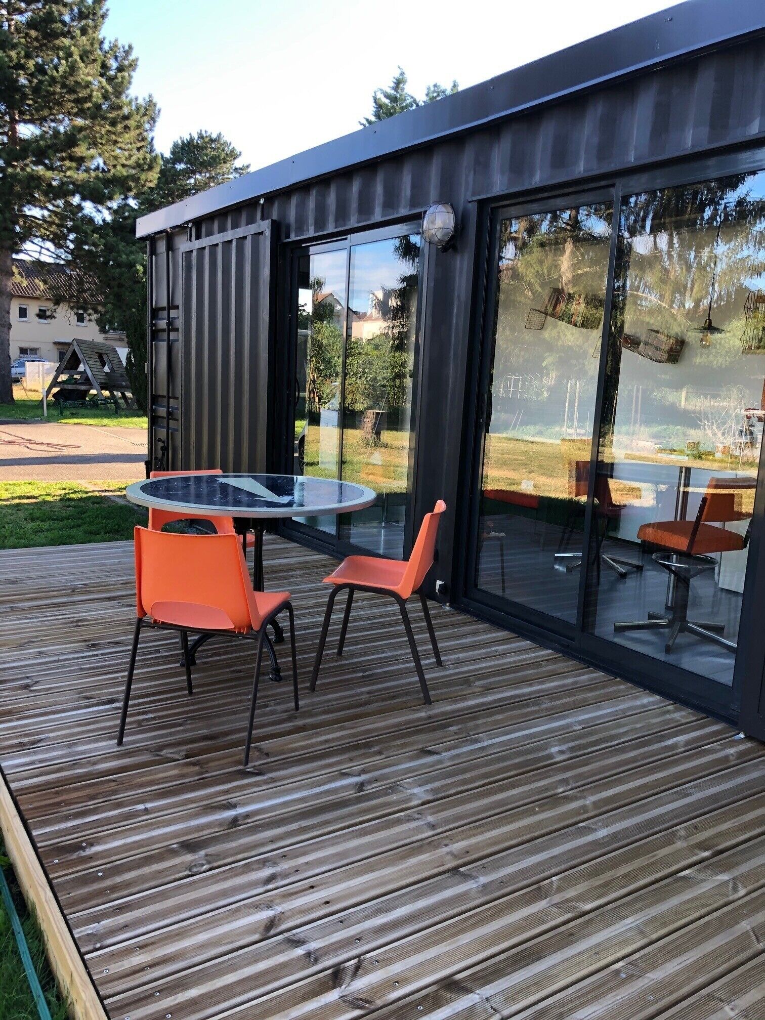 Eine moderne Außenterrasse mit Glastür, die zu einem Patio führt.