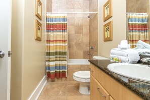 A bathroom with a shower, toilet, and sink. - Charming Amenity Level Condo with Smart TV and Easy Pool Access. Complimentary Boat Slip! (Orange Beach)