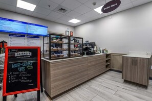 A cafe with a counter, menu boards, and a sign indicating a special offer.