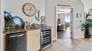 A kitchen with a clock, an anchor decoration, and a welcome sign.