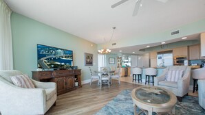 Amplia sala de estar con comedor, cocina y un gran ventanal con vista panorámica de la ciudad.