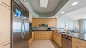 Una cocina moderna con electrodomésticos de acero inoxidable, armarios de madera y una isla grande con un fregadero.