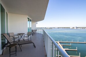 Relax on the balcony with lounge chairs and a small table, taking in the serene views of the marina.