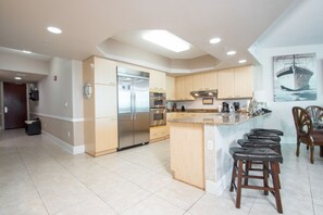 Enjoy cooking in this well-equipped kitchen with a central island, stainless steel appliances, and a large window.