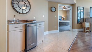 A modern kitchen with a built-in dishwasher, a clock, and a ceiling fan. - Exquisite Three Bedroom Condo with Wraparound Balcony and Gulf Views! Complimentary Boat Slip! (Orange Beach)