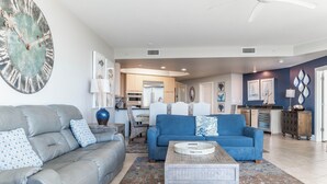 Ein modernes Wohnzimmer mit einem grauen Sofa, einem blauen Sofa und einem Couchtisch.
