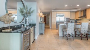 Una cocina moderna con una isla central, electrodomésticos de acero inoxidable y un espejo grande.