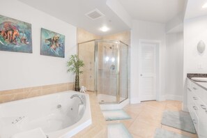 Een bad/douchecombinatie, een bubbelbad, een haardroger, handdoeken