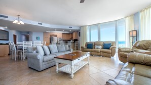A spacious living area with a dining table, two sofas, and a kitchen in the background. - Updated Family-Friendly Condo with Media Room and Wraparound Balcony. Complimentary Boat Slip! (Orange Beach)