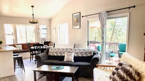 Un salon spacieux comprenant un canapé, une table basse et un coin repas avec des chaises et une table.