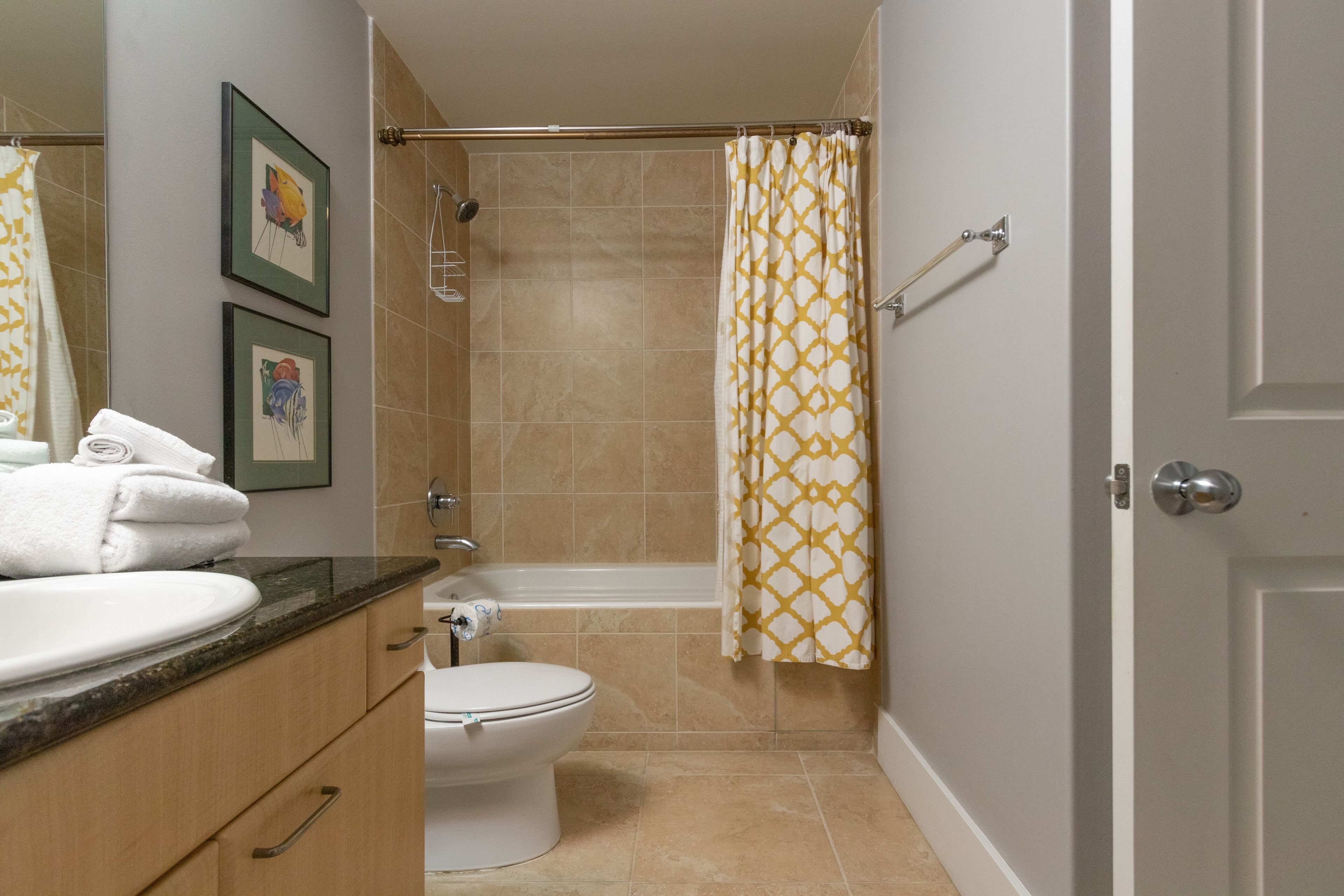 Une salle de bain comprenant des toilettes, un lavabo et un espace douche.