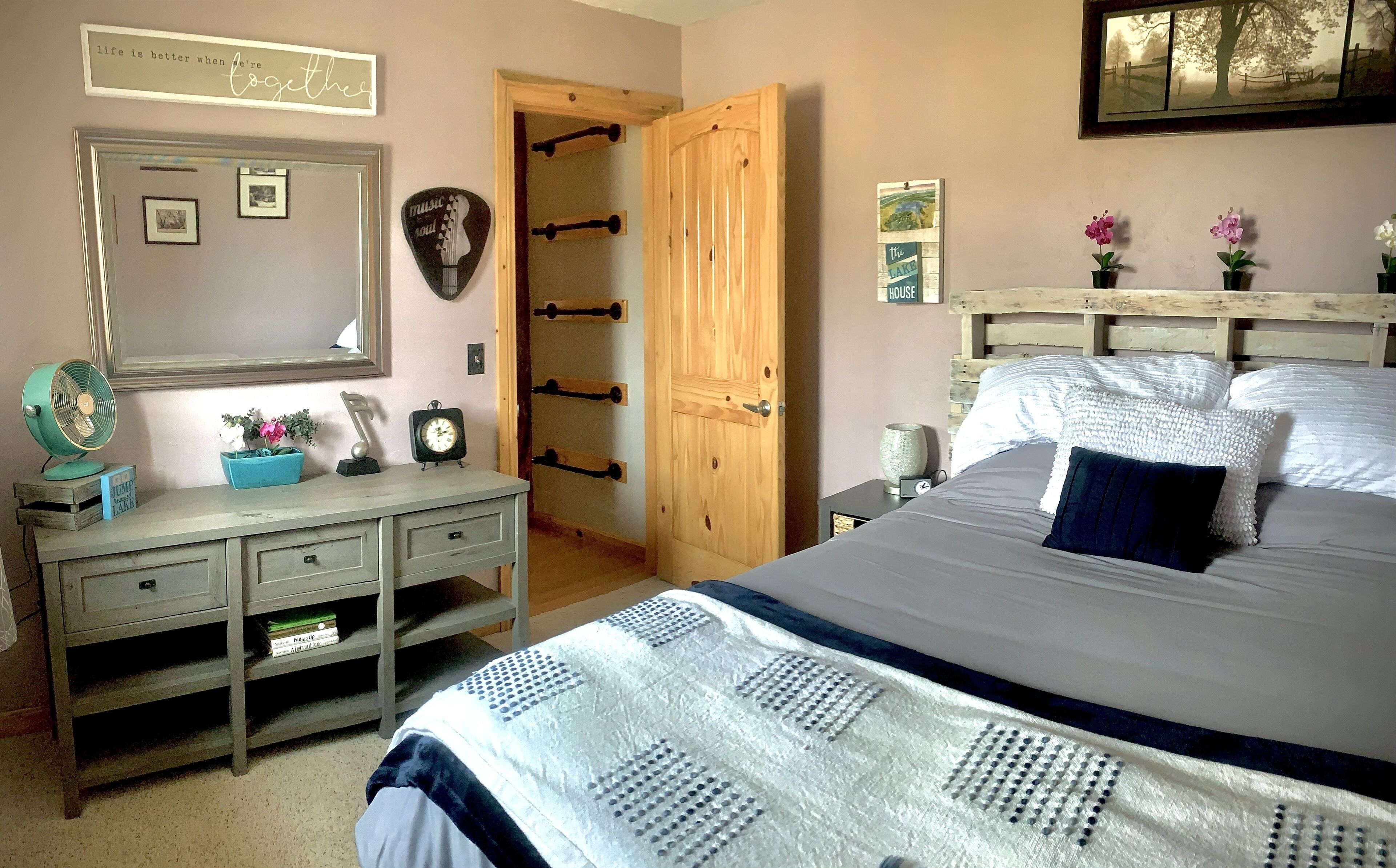 Een slaapkamer met een bed, een kaptafel en een houten deur.
