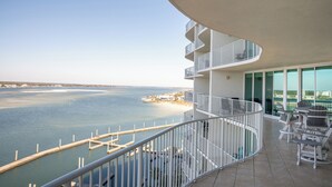 En balkon med udsigt over en lysthavn og en strand.