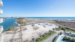 Um imóvel à beira-mar com piscina, estacionamento e vista para o oceano e o horizonte da cidade.