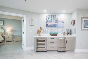 A modern kitchen with a built-in oven, a sink, and a countertop. There is a painting of a boat on the wall above the counter.