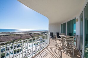 Enjoy the ocean view from this balcony with a pool and lounge area below.