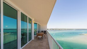 Un balcon avec vue sur la mer, une table avec des chaises et une rambarde.