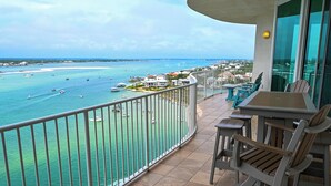 Un balcon avec vue sur la mer, une table et des chaises.