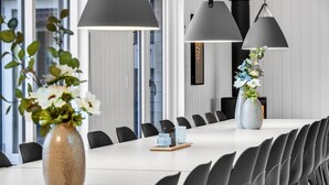 A conference room with a long table, black chairs, and two vases with flowers. - Nice home in Sydals with sauna (Sydals)