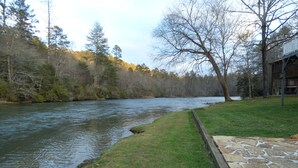 A riverside view with a stone pathway leading to a wooden structure. - Winter in the mountains, fishing by the fire pit. Murphy and the Casino nearby. (Murphy)