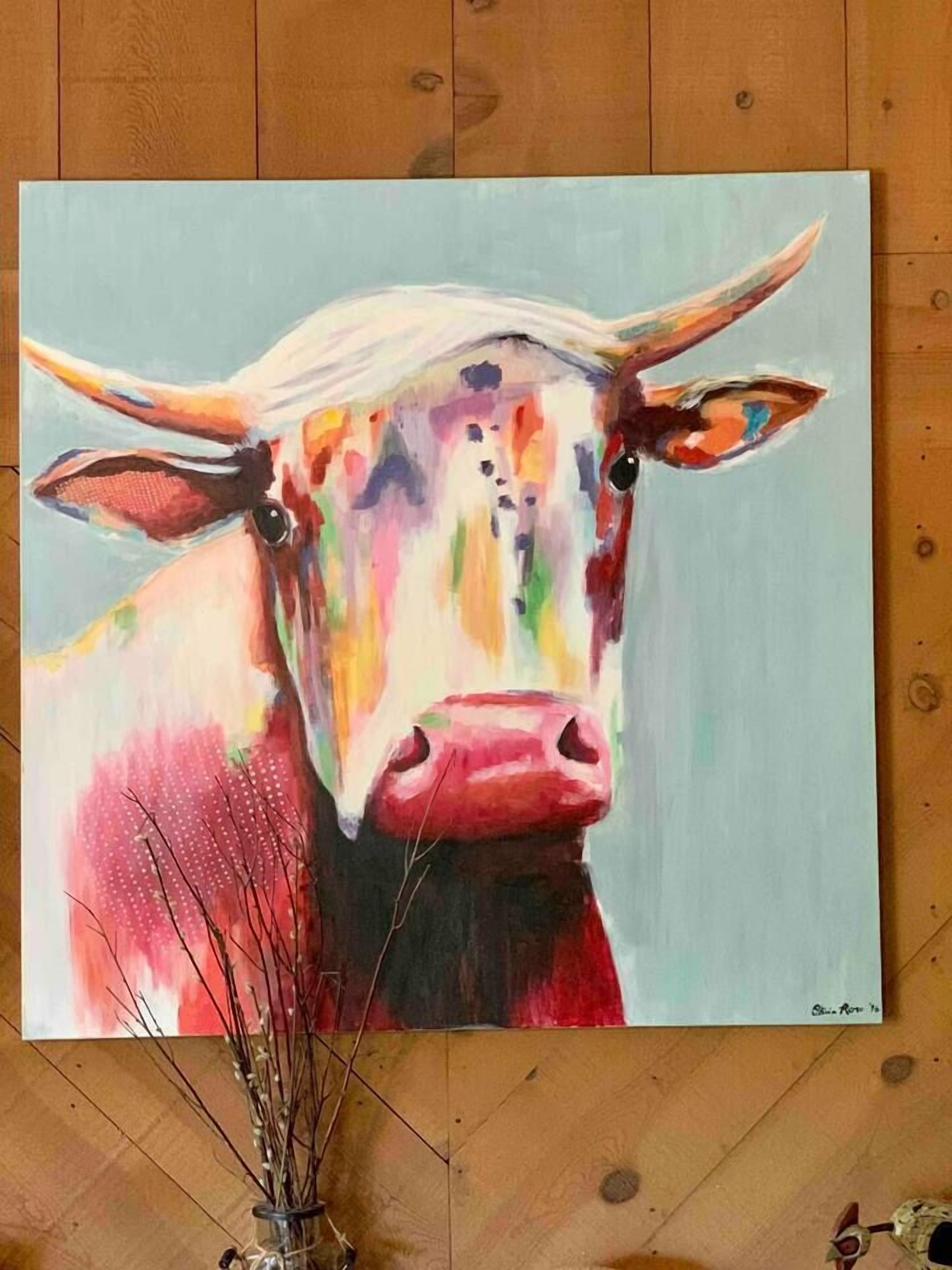A painting of a cow on a wooden floor.