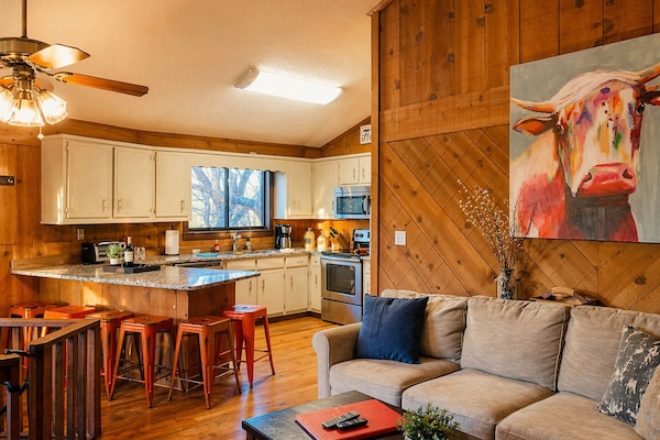 Warm wood tones, cozy seating, and a kitchen made for gathering—this is where mountain mornings start and memories are made with a stunning cow picture painted by our niece!