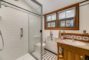 Bathroom features a glass-enclosed shower, toilet, and sink with a vanity.