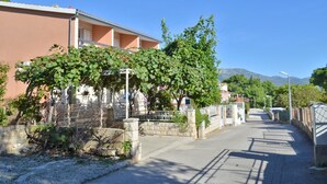Una calle residencial con casas, cielo despejado y montañas al fondo.