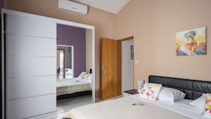 Ein Schlafzimmer mit Bett, Kleiderschrank, Nachttisch und einem Bild an der Wand.