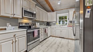 A kitchen with white cabinets, stainless steel appliances, and a wooden ceiling. - Waterfront 3BR/3BA Getaway: Beach, Dock, Firepit! AMAZING Sweeping VIEWS! (Heathsville)