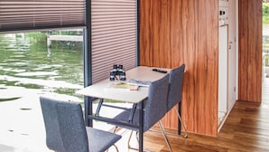 Ein modernes Zimmer mit einer Holzwand, einem Tisch mit Fernbedienung, Fernglas und einem Buch.