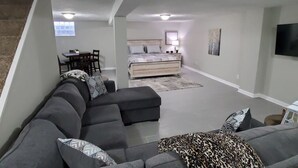 Una sala moderna con un sofá modular, una cama y un comedor.