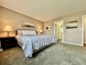 Een slaapkamer met een bed, nachtkastjes en wanddecoratie.