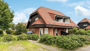 Een twee verdiepingen tellend huis met een schuin dak, bakstenen muren en een schotelantenne.