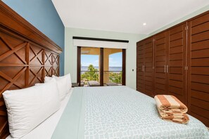 A hotel room with a bed, a balcony with a view, and a wardrobe.