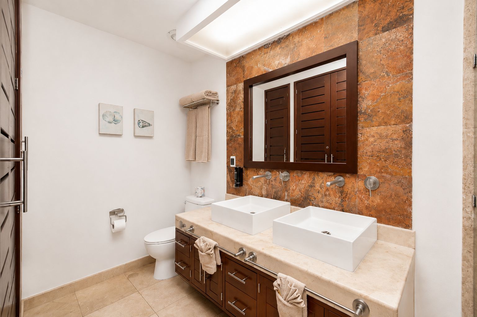 Une salle de bain moderne avec deux lavabos, des toilettes et un espace douche.
