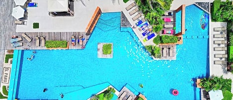 A large outdoor swimming pool with multiple lounge areas and sunbeds.