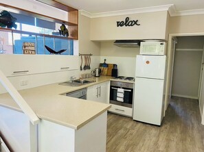 Enjoy cooking in this kitchen with a microwave, oven, refrigerator, sink, and utensils.