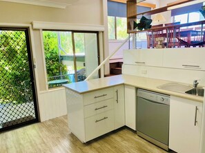 Enjoy a meal in the kitchen with a sink and island, and step out to a balcony with a view of the surrounding greenery.