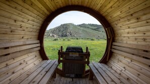 A wooden cabin with a circular window, a bench, and a caution sign. - Modern Home w/ Great Private Views, Hot Tub & Sauna (Tabernash)