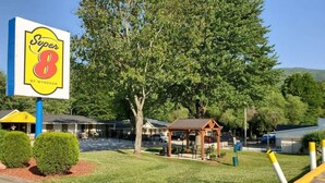A Super 8 motel with a large sign, a covered picnic area, and a parking lot. - Super 8 By Wyndham Asheville Biltmore (Asheville)