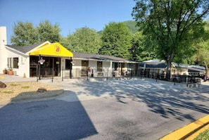 A motel with a yellow awning, a covered front porch, and a parking area with a yellow curb. - Super 8 By Wyndham Asheville Biltmore (Asheville)