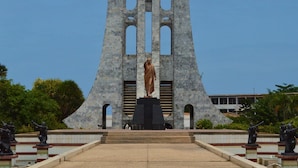 A monument with a central statue, surrounded by a tiled walkway and statues on either side. - Room-single Room - 1st Floor (Accra)